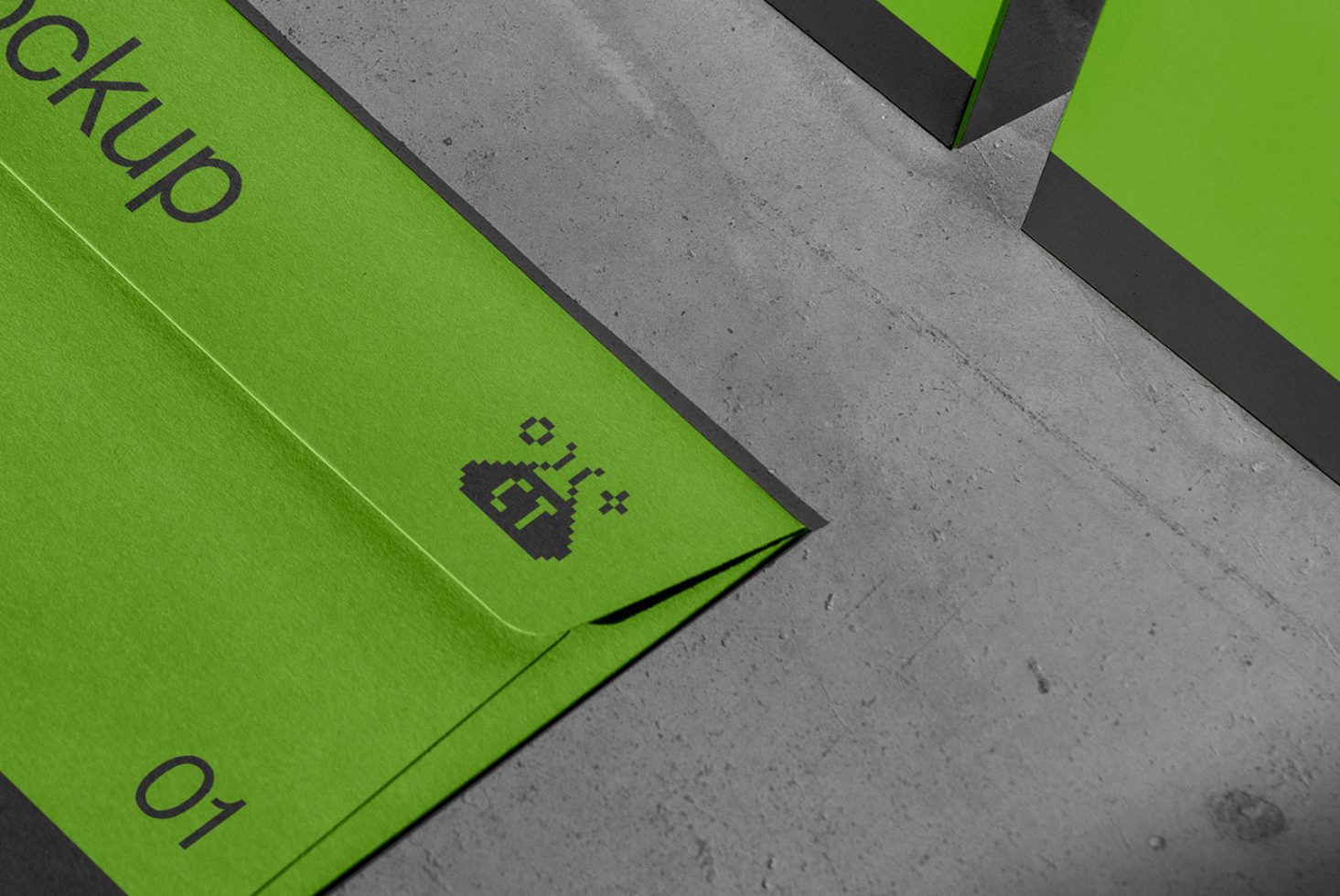 Green envelope mockup on concrete background with pixelated cursor design, showcasing bold graphics and modern branding for designers.